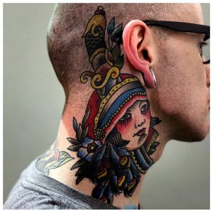 Яркая татуировка на шее за ухом