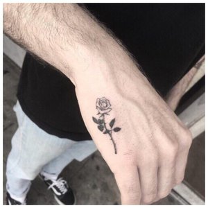 Маленькая роза - татуировка на руке мужчины