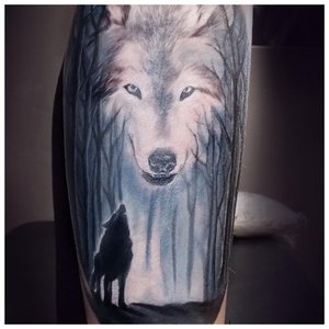 Татуировка волка на икре у мужчины