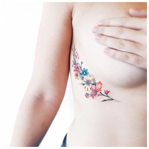Цветная цветочная тату под грудью сбоку