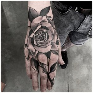 Черная роза тату на руке у мужчины 