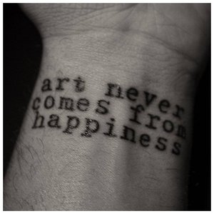 Тату-надпись "Искусство никогда не получается из счастья"