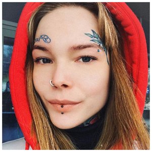 Девушка с татуировками над бровями