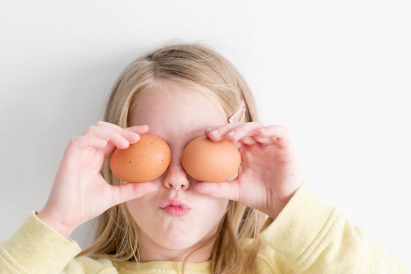 Девочка фотографируется с яйцами