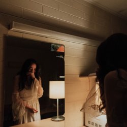 Девушка плачет у зеркала