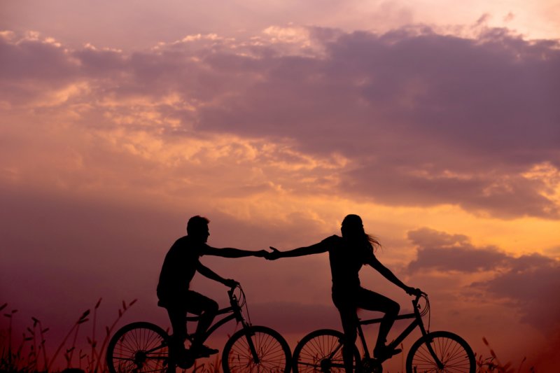 Парень и девушка на велосипедах на закате
