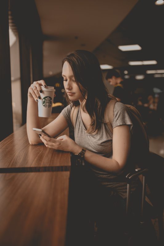Девушка в кафе с телефоном