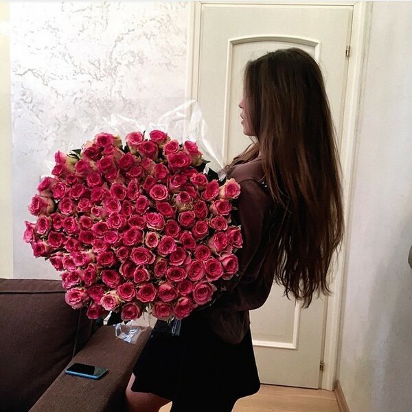 Девушка с длинными волосами и большим букетом роз