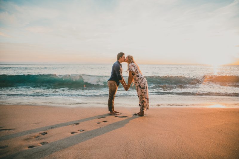 Парень и девушка целуются на берегу моря